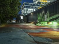 a colorful street has a rainbow in the middle with a building next to it and a few steps leading up to a ramp at the corner