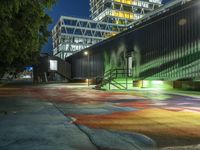 a colorful street has a rainbow in the middle with a building next to it and a few steps leading up to a ramp at the corner