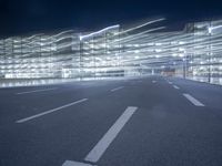an empty parking lot at night with clear windows and parking lights on the side of it