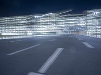 an empty parking lot at night with clear windows and parking lights on the side of it