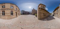 a fish - eye lens image showing a street with brick buildings on either side and several smaller circular ones on the other side