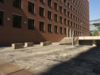 empty sidewalk outside the side of a brick building in a city setting on a sunny day