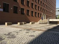 empty sidewalk outside the side of a brick building in a city setting on a sunny day