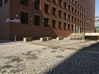 empty sidewalk outside the side of a brick building in a city setting on a sunny day