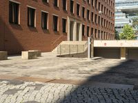 empty sidewalk outside the side of a brick building in a city setting on a sunny day