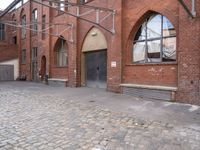 an alley with cobblestone paving and arched arched windows on the side of the building