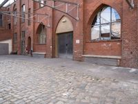 an alley with cobblestone paving and arched arched windows on the side of the building