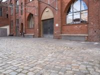 an alley with cobblestone paving and arched arched windows on the side of the building