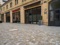 a bricked walkway on the outside of a building with two motorcycles parked near by