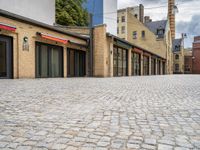 a brick road in a city with several different shops and stores on either side of each street