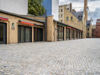 a brick road in a city with several different shops and stores on either side of each street