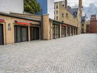 a brick road in a city with several different shops and stores on either side of each street