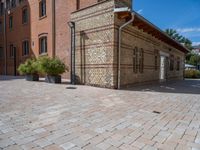 two buildings on a brick walkway beside each other, each one brick with the same color