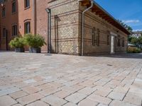 two buildings on a brick walkway beside each other, each one brick with the same color