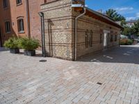 two buildings on a brick walkway beside each other, each one brick with the same color