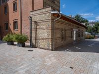 two buildings on a brick walkway beside each other, each one brick with the same color