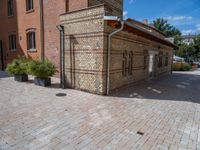 two buildings on a brick walkway beside each other, each one brick with the same color