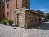 two buildings on a brick walkway beside each other, each one brick with the same color