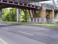 a motorcyclist is under an overpass in the middle of a street