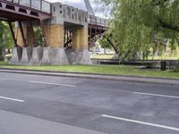 a motorcyclist is under an overpass in the middle of a street