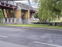 a motorcyclist is under an overpass in the middle of a street