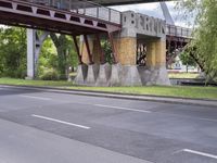 a motorcyclist is under an overpass in the middle of a street