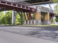 a motorcyclist is under an overpass in the middle of a street