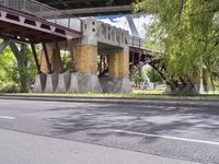 a motorcyclist is under an overpass in the middle of a street