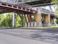 a motorcyclist is under an overpass in the middle of a street