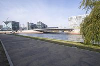 a bridge that runs over a body of water with buildings in the background and another one on either side of it