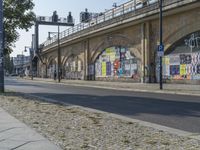 an older bridge over a street with graffiti on it's walls and walkways