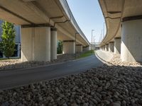 a freeway bridge that's connected to several piers next to a rock filled street