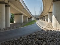 a freeway bridge that's connected to several piers next to a rock filled street