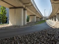 a freeway bridge that's connected to several piers next to a rock filled street