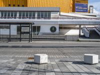 a empty sidewalk at an airport with benches near the walkway and stairs leading up to the terminal