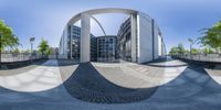 a fish - eye view of a building's front, seen through some circular mirrors