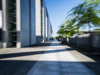 the picture is of a long sidewalk outside of a building, looking blurry at one end