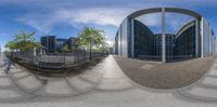 a photo of a very large building with some trees in it's yard and a view through a round mirror