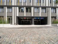 two buildings with a parking garage under one roof and a sidewalk in front of them