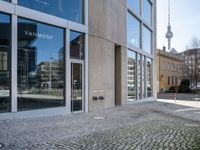 the entrance to a building on a street corner next to large windows with multiple pictures on them