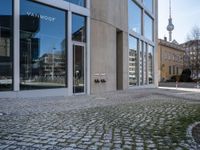 the entrance to a building on a street corner next to large windows with multiple pictures on them