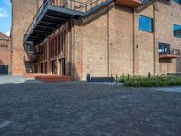 the red brick building has a wrought iron railing over it's roof, and on the left side it is a red brick wall