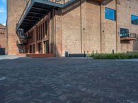 the red brick building has a wrought iron railing over it's roof, and on the left side it is a red brick wall