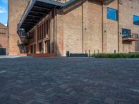 the red brick building has a wrought iron railing over it's roof, and on the left side it is a red brick wall