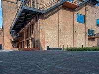 the red brick building has a wrought iron railing over it's roof, and on the left side it is a red brick wall