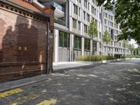 the sidewalk has yellow paint on it and an empty building in the background with trees