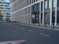 the empty street with bicycles parked in front of the buildings has a sign that says the library on it