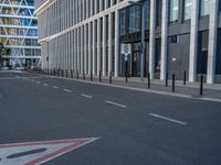 the empty street with bicycles parked in front of the buildings has a sign that says the library on it