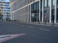 the empty street with bicycles parked in front of the buildings has a sign that says the library on it