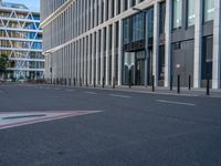 the empty street with bicycles parked in front of the buildings has a sign that says the library on it